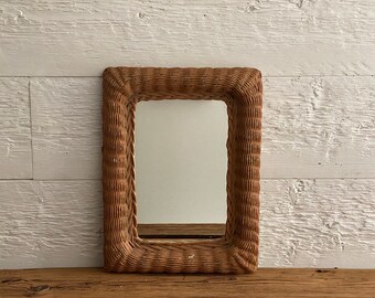 Vintage mirror in wicker frame  with old layers of blue and orange paint