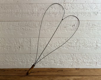 Antique heart-shaped wire metal rug beater, with a wooden handle