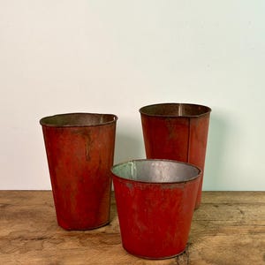 Eine Auswahl an antiken / Vintage-Ahornsirup-Blecheimern mit ihrer ursprünglichen roten Farbe aus Quebec, Kanada, um 1940er Jahre