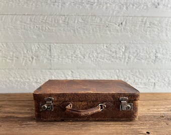 Antique leather suitcase, luggage, with a handle and silver latches, circa 1930s