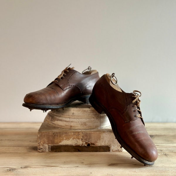 Antique/vintage men's brown leather golf shoes with leather soles and metal cleats, with size ten shoe lasts