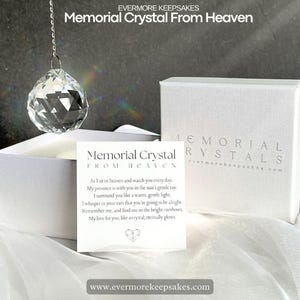 May include: A white box containing a clear crystal ball suspended from a silver chain. The box is labelled "Memorial Crystals" and "www.evermorekeepsakes.com". A card inside the box reads "Memorial Crystal From Heaven" and features a poem about love and remembrance.