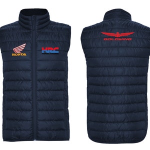May include: A navy blue quilted vest with a zipper closure. The vest has three embroidered logos: Honda, HRC Honda Racing, and Goldwing. The Goldwing logo is on the back of the vest.