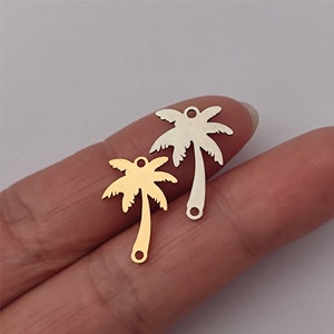 May include: Two palm tree charms, one gold and one silver, with a hole at the top for attaching to jewelry or other crafts.