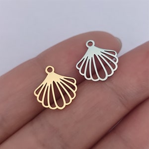 May include: Two metal seashell charms, one gold and one silver, with a loop at the top for attaching to jewelry or crafts.
