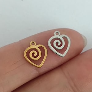 May include: Two metal heart-shaped charms with a spiral design. One charm is gold and the other is silver.