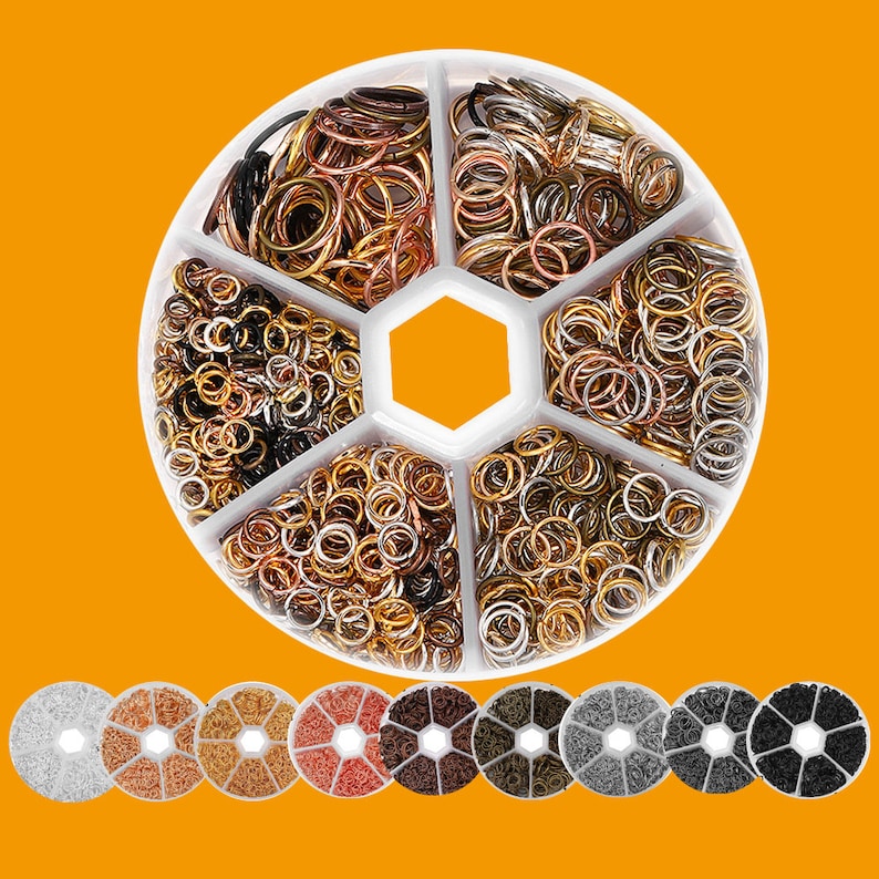May include: A round white container with six compartments filled with various sizes of gold, silver, and copper jump rings. The container is divided into six sections, each containing a different color of jump rings. The container is on a yellow background.