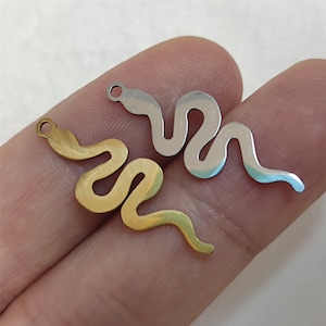 May include: Two metal snake charms, one gold and one silver, with a loop at the top for attaching to jewellery.