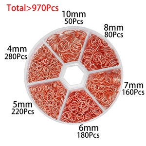 May include: A clear plastic container with six compartments filled with different sizes of copper jump rings. The container is labeled with the size and quantity of each ring, for example, "4mm 280Pcs".