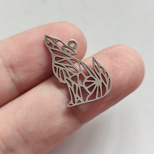 Peut inclure: Breloque en métal argenté en forme de loup hurlant à la lune. Le loup est fait d'un design délicat et complexe.