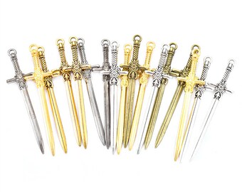 May include: A collection of 16 miniature sword charms in gold and silver tones. The swords have intricate details and are perfect for adding a touch of fantasy to jewelry or crafts.