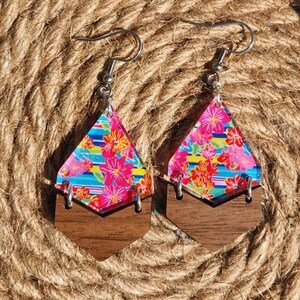 May include: A pair of wooden earrings with a geometric shape and a colorful floral pattern. The earrings are made of wood and have a silver hook.
