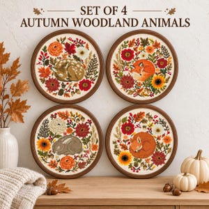May include: A set of four circular cross-stitch embroideries in dark wood frames, each featuring an autumn woodland animal—a fawn, a fox, a rabbit, and a squirrel—surrounded by colorful fall flowers, leaves, and acorns, with the text SET OF 4 AUTUMN WOODLAND ANIMALS.