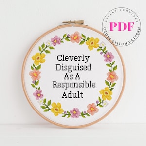 Peut inclure: Un cercle de broderie au point de croix avec le texte "Cleverly Disguised As A Responsible Adult" en noir. Le texte est entouré d'une couronne florale de fleurs jaunes, roses et pêche. Un tampon de téléchargement PDF est dans le coin supérieur droit.