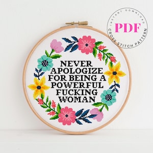 Könnte beinhalten: Ein Kreuzstich-Stickrahmen mit dem Text "NEVER APOLOGIZE FOR BEING A POWERFUL FUCKING WOMAN", umgeben von einem floralen Kranz in Rosa, Gelb und Türkis. Die Worte "INSTANT DOWNLOAD PDF CROSS STITCH PATTERN" sind in einem Kreis.