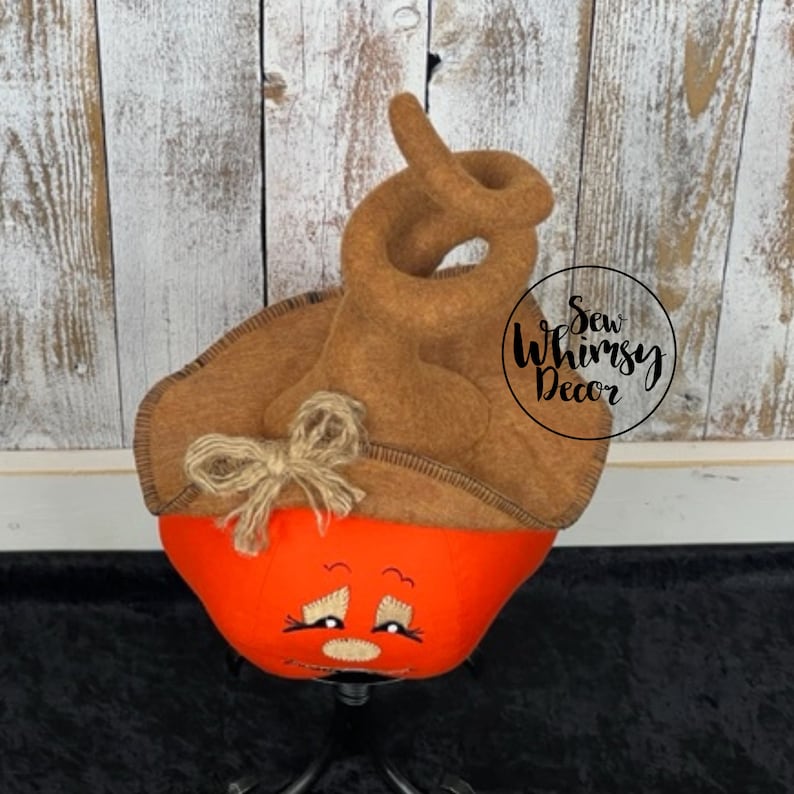 Pu&ograve; includere: Decorazione a forma di zucca fatta a mano con volto ricamato. La base arancione &egrave; sormontata da un cappello marrone in feltro con un motivo a spirale e un fiocco di spago. Adatta per Halloween o decorazioni autunnali.
