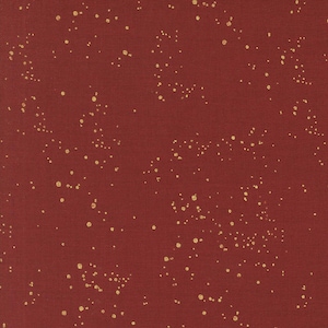 May include: Close-up of a textured, dark red fabric with a pattern of scattered gold dots. The dots vary in size and density, creating a speckled effect across the surface. The fabric has a subtle woven texture.