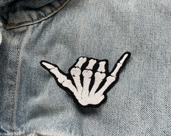 Parche termoadhesivo bordado con el signo de Shaka "Surfs up" de la mano de esqueleto