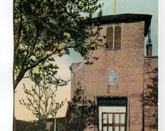 May include: Vintage postcard of San Miguel Church in Santa Fe, New Mexico. The church, built of brick, has a cross on the roof and a bell tower. The text reads "SAN MIGUEL CHURCH. OLDEST IN THE UNITED STATES. SANTA FE, NEW MEXICO."