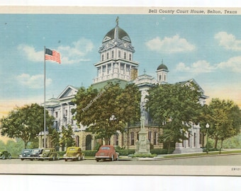 May include: A vintage postcard featuring the Bell County Court House in Belton, Texas. The image shows a multi-story stone building with a central dome, a tall flagpole with an American flag, and several classic cars parked in front.