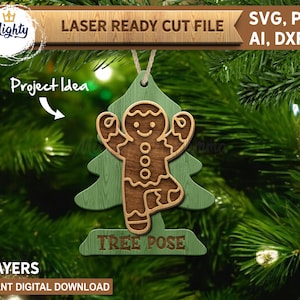 May include: A two-layer wooden Christmas ornament featuring a gingerbread man in a tree pose. The ornament is brown and green, with the words "TREE POSE" at the bottom. The text "LASER READY CUT FILE" and "SVG, PDF, AI, DXF" are also visible.