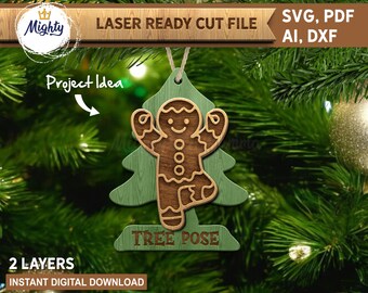 May include: A two-layer wooden Christmas ornament featuring a gingerbread man in a tree pose. The ornament is brown and green, with the words "TREE POSE" at the bottom. The text "LASER READY CUT FILE" and "SVG, PDF, AI, DXF" are also visible.