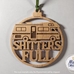 May include: Wooden Christmas ornament in the shape of a circle with a cutout of a recreational vehicle. The words "SHITTERS FULL" are cut out below the RV. A green ribbon is attached for hanging. The Mighty Mamma Designs logo is in the lower right.
