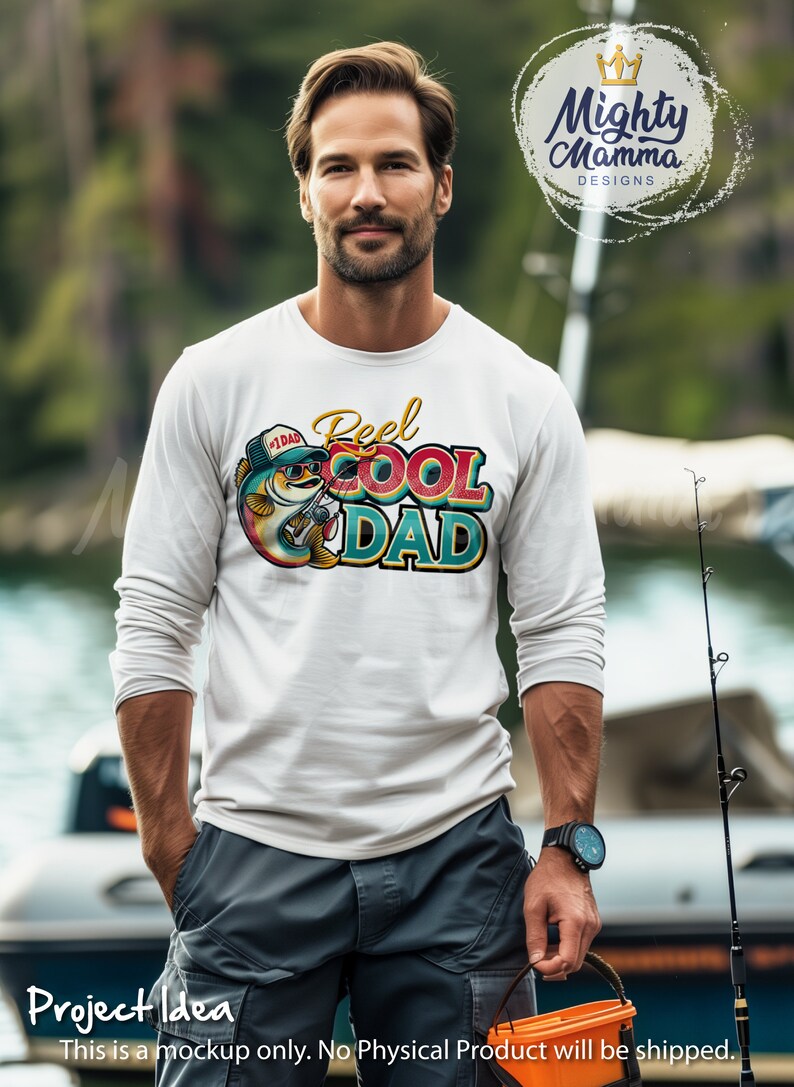 Peut inclure: Un t-shirt blanc &agrave; manches longues avec un motif color&eacute; d'un poisson portant des lunettes de soleil et un chapeau qui dit "#1 DAD". Le motif comprend &eacute;galement le texte "Reel Cool Dad".