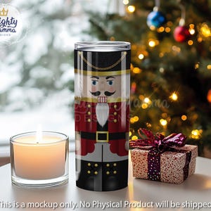 May include: A stainless steel tumbler with a red, white, and black nutcracker design. The nutcracker is wearing a red and white hat and has a black mustache.