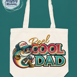 Peut inclure: Un sac fourre-tout blanc avec un poisson de dessin anim&eacute; portant des lunettes de soleil et un chapeau qui dit "#1 Dad". Le poisson tient une canne &agrave; p&ecirc;che et le texte "Reel Cool Dad" est en grandes lettres color&eacute;es.