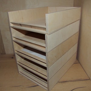 Peut inclure: Un organisateur en bois avec six étagères pour ranger des papiers ou d'autres articles. L'organisateur est en bois clair et a un design simple et fonctionnel.