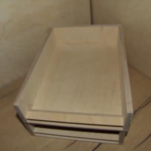 Può includere: Un set di due scatole di legno non finite, impilate l'una sull'altra. Le scatole sono in legno chiaro e hanno una forma rettangolare semplice.