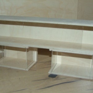 May include: A white wooden display case with two shelves and clear acrylic sides. The case is empty.