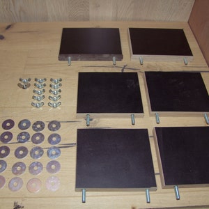 May include: A set of six black square wooden shelves with metal brackets and screws. The set also includes a bag of silver washers and nuts.