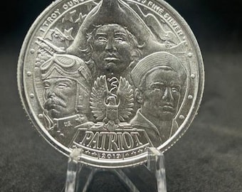 May include: A silver coin featuring portraits of historical figures. The coin is marked with the words "1 Troy Ounce" and ".999 Fine Silver." The word "PATRIOT" is inscribed on the coin, along with the year 2012.