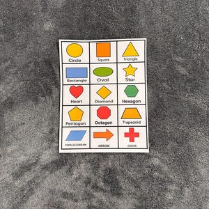 May include: A white card featuring various shapes and their names. Shapes include a circle, square, triangle, rectangle, oval, star, heart, diamond, hexagon, pentagon, octagon, trapezoid, parallelogram, arrow, and cross.