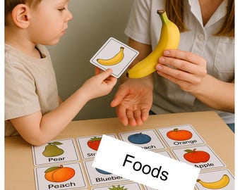 May include: A child and an adult are interacting with fruit flashcards and a banana. The flashcards display various fruits, including a pear, strawberry, peach, blueberry, orange, apple, raspberry, banana, pineapple, and kiwi. The text "Foods" and "Food Therapy pec" are visible.