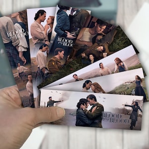 May include: A hand holding a collection of rectangular cards with images from a historical drama. The cards show couples, soldiers, and landscapes. The title "BLOOD of the BLOOD" is printed on some of the cards.