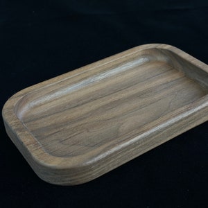 Peut inclure: Un plateau rectangulaire en bois avec une finition brun clair et une surface lisse légèrement arrondie. Le plateau est en bois avec un motif de grain naturel.