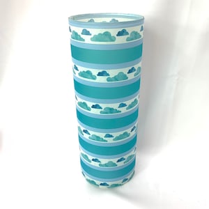 May include: A tall, cylindrical glass vase with a frosted finish. The vase is decorated with a repeating pattern of blue and white watercolour clouds and stripes.