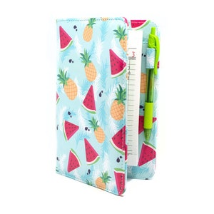 May include: A blue notebook with a watermelon and pineapple pattern. The notebook has a pen holder and a ruler on the side.