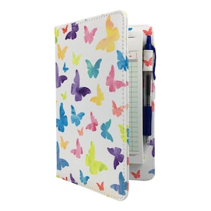 May include: A white leatherette notepad with a colorful butterfly pattern and a blue pen. The notepad has a lined section for writing and a section for receipts.