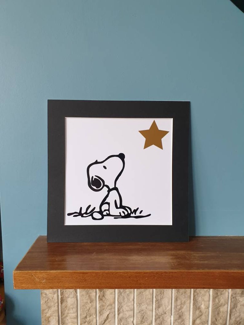Unframed. Snoopy looking at star 12 inch x 12 inch vinyl picture on quality 500 gsm card with a black mount