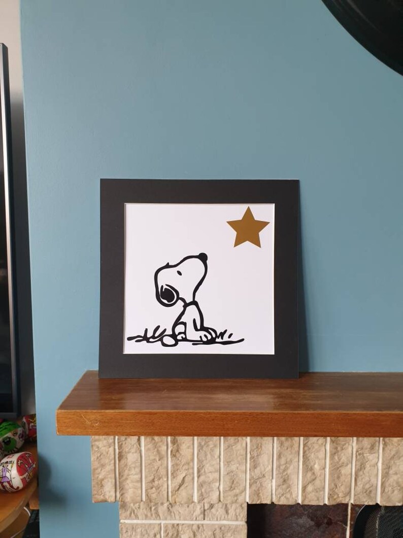 Unframed. Snoopy looking at star 12 inch x 12 inch vinyl picture on quality 500 gsm card with a black mount