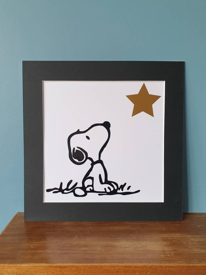 Unframed. Snoopy looking at star 12 inch x 12 inch vinyl picture on quality 500 gsm card with a black mount