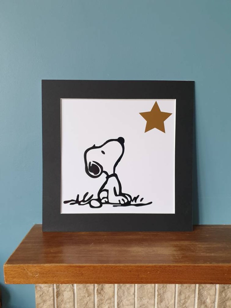 Unframed. Snoopy looking at star 12 inch x 12 inch vinyl picture on quality 500 gsm card with a black mount