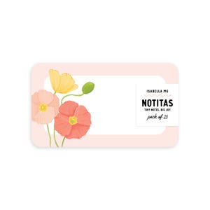 May include: A rectangular, light pink note card with rounded corners. Watercolor flowers in shades of yellow, peach, and coral are on the left. The card has the text "ISABELLA MG" and "NOTITAS TINY NOTES. BIG JOY pack of 25".