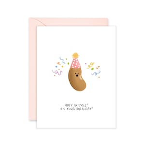 May include: A white greeting card with a light pink envelope featuring a brown bean character wearing a pink polka-dot party hat with a yellow pom-pom. Colorful confetti surrounds the bean, and the text reads: HOLY FRIJOLE! IT'S YOUR BIRTHDAY!