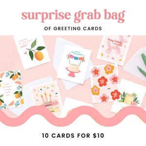 May include: A set of 10 greeting cards with various designs, including a birthday card with a cake, a congratulations card with a citrus fruit, and a card with a balloon animal. The cards are arranged on a pink background with the text "surprise grab bag of greeting cards" and "10 cards for $10".