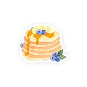 May include: A stack of golden brown pancakes topped with banana slices, blueberries, and a drizzle of maple syrup.